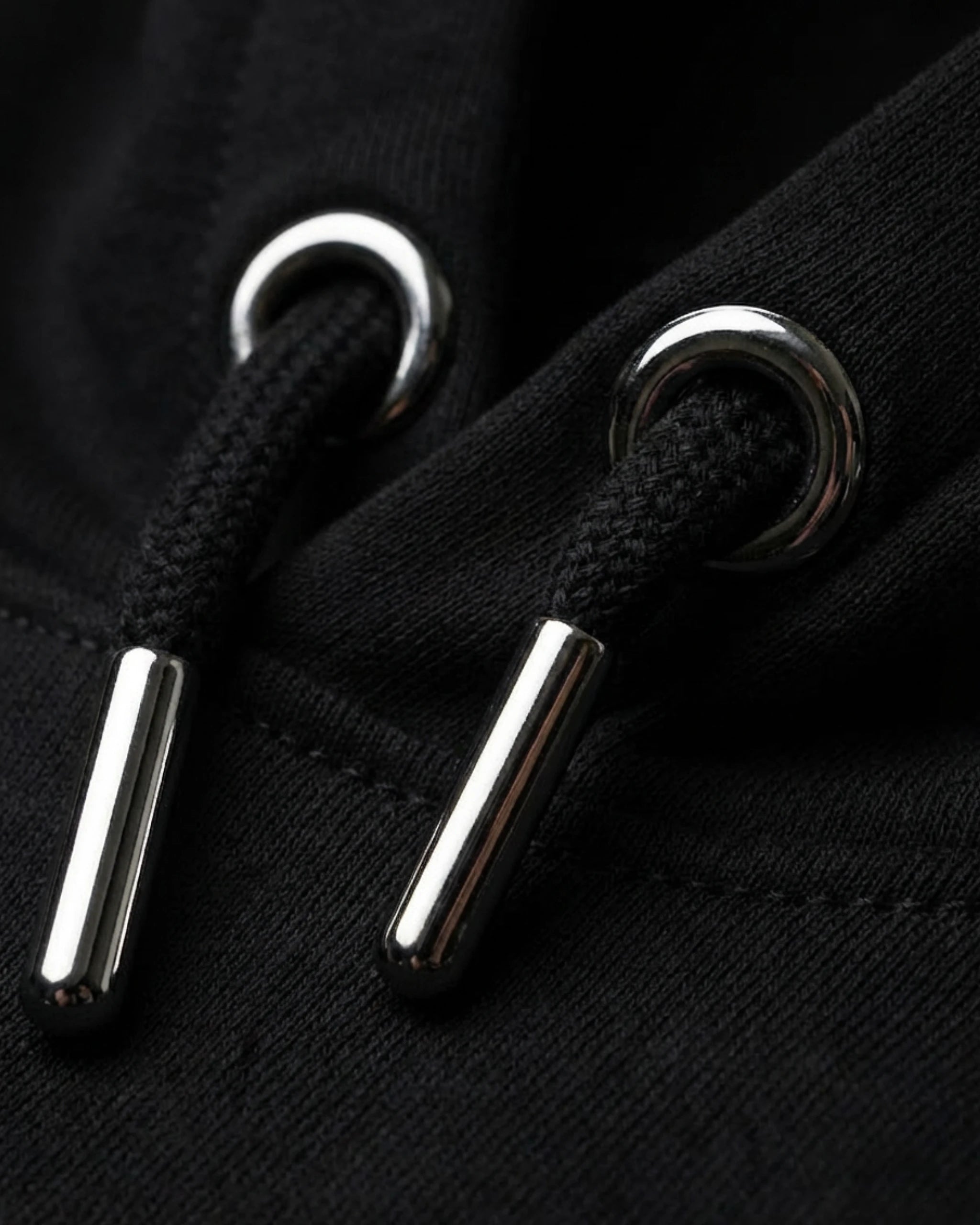 Detailaufnahme der hochwertigen Kordeln mit Metallenden am "No Problama" Hoodie in Schwarz.
